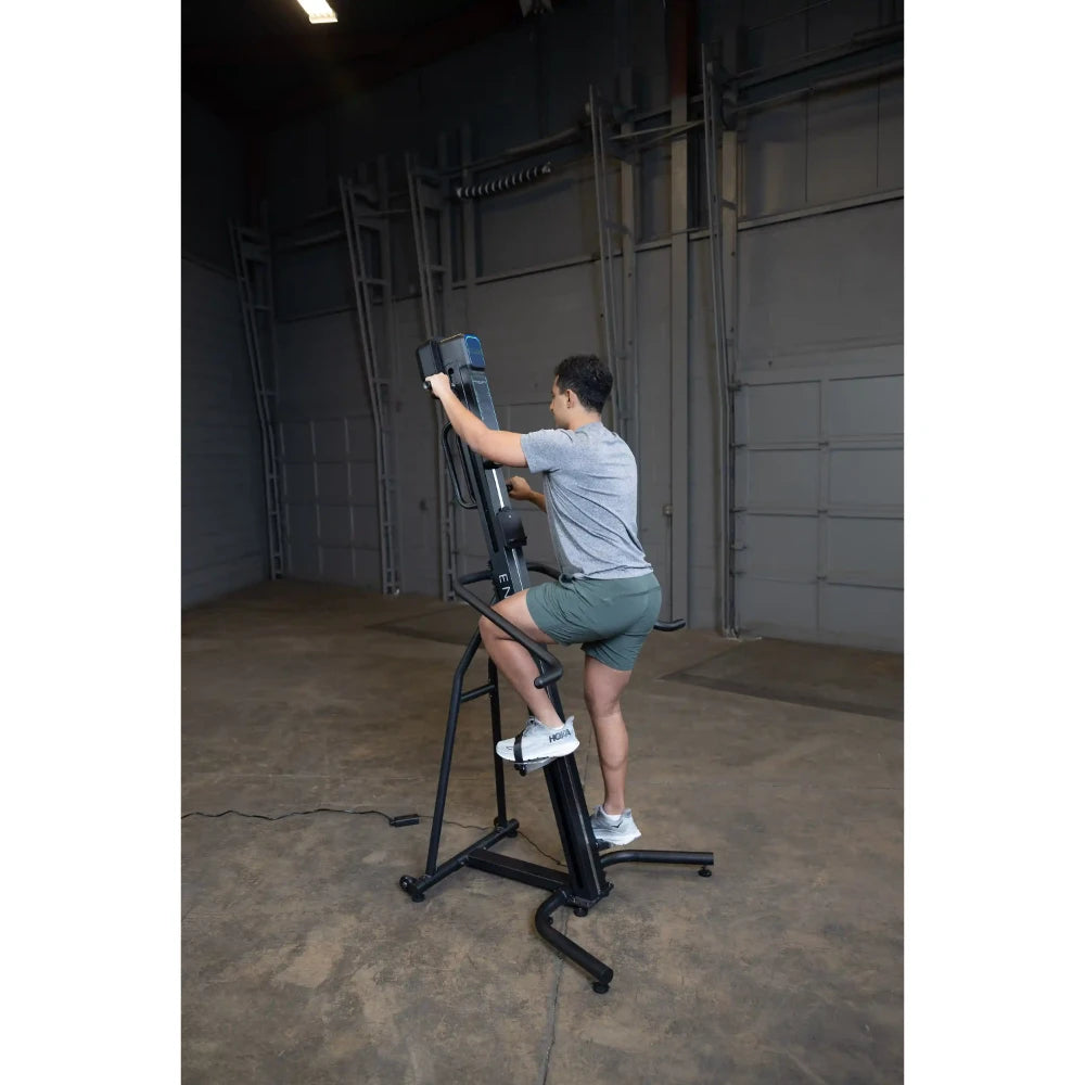 Man using a black vertical climber machine in a gym for effective cardio workout.