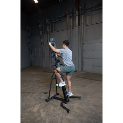 Man using a black vertical climber machine in a gym for effective cardio workout.