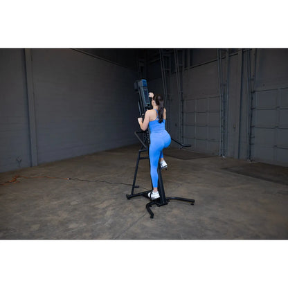 Woman in blue workout gear using a vertical climber machine in a gym.
