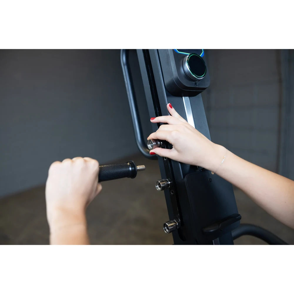 Adjusting resistance on a black rowing machine with red nail polish.