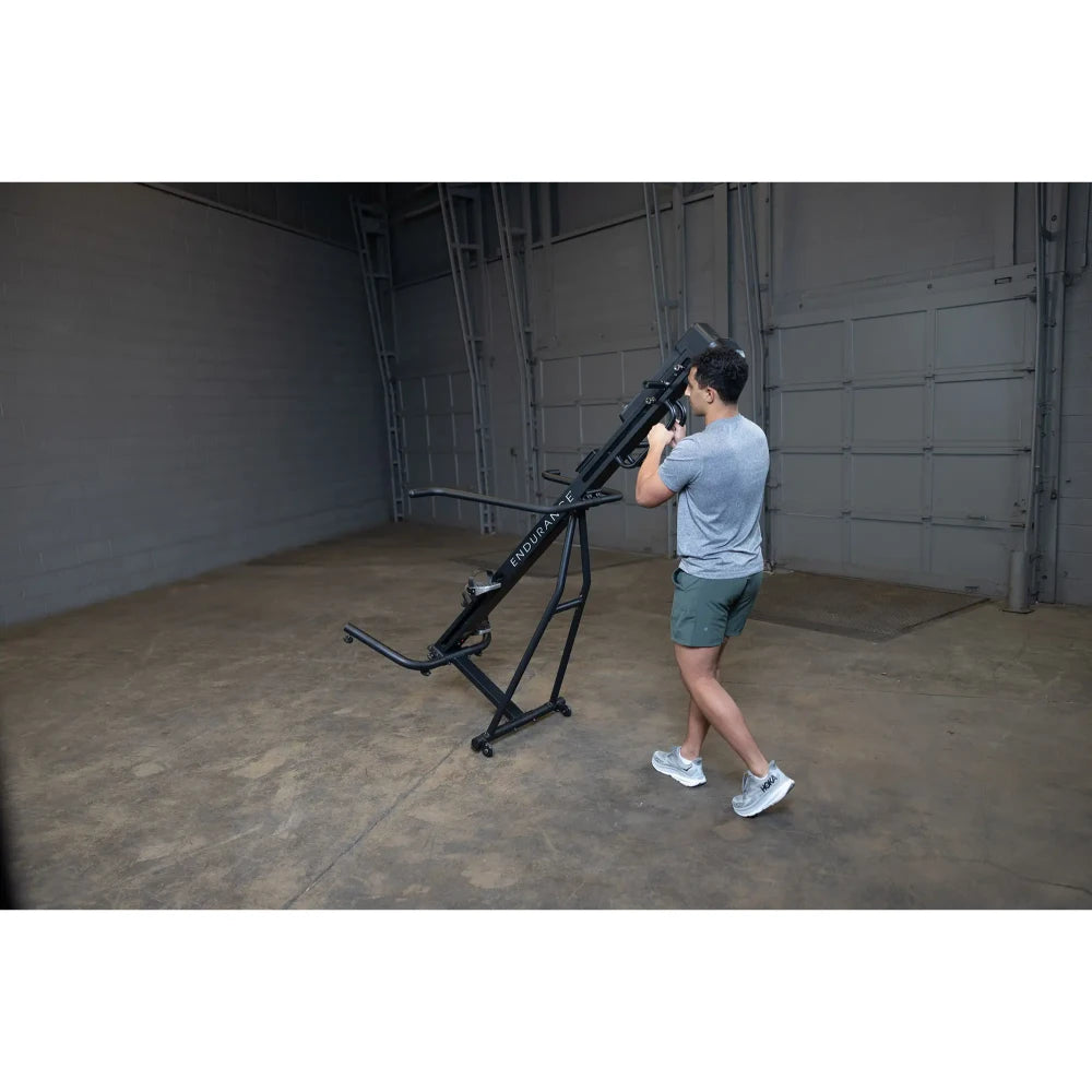 Man using black ENDURA Fitness rowing machine in a spacious gym.