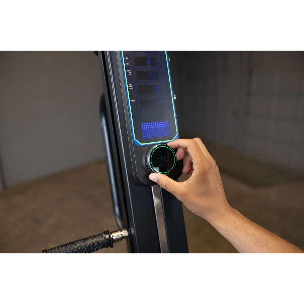 Hand adjusting resistance on a black PowerMax fitness bike console.