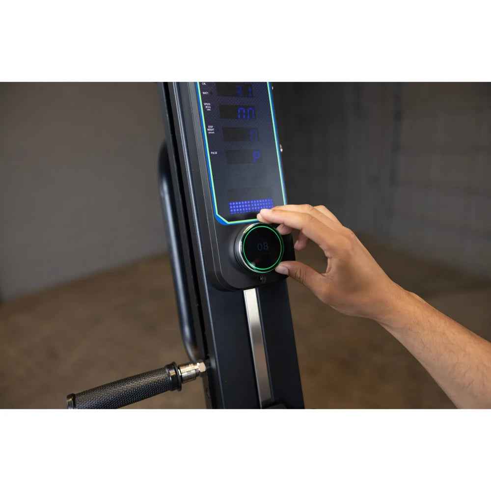 Adjusting resistance on a black rowing machine's digital display with a control knob.