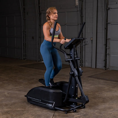 Woman exercising on Endurance E300 elliptical in a gym.