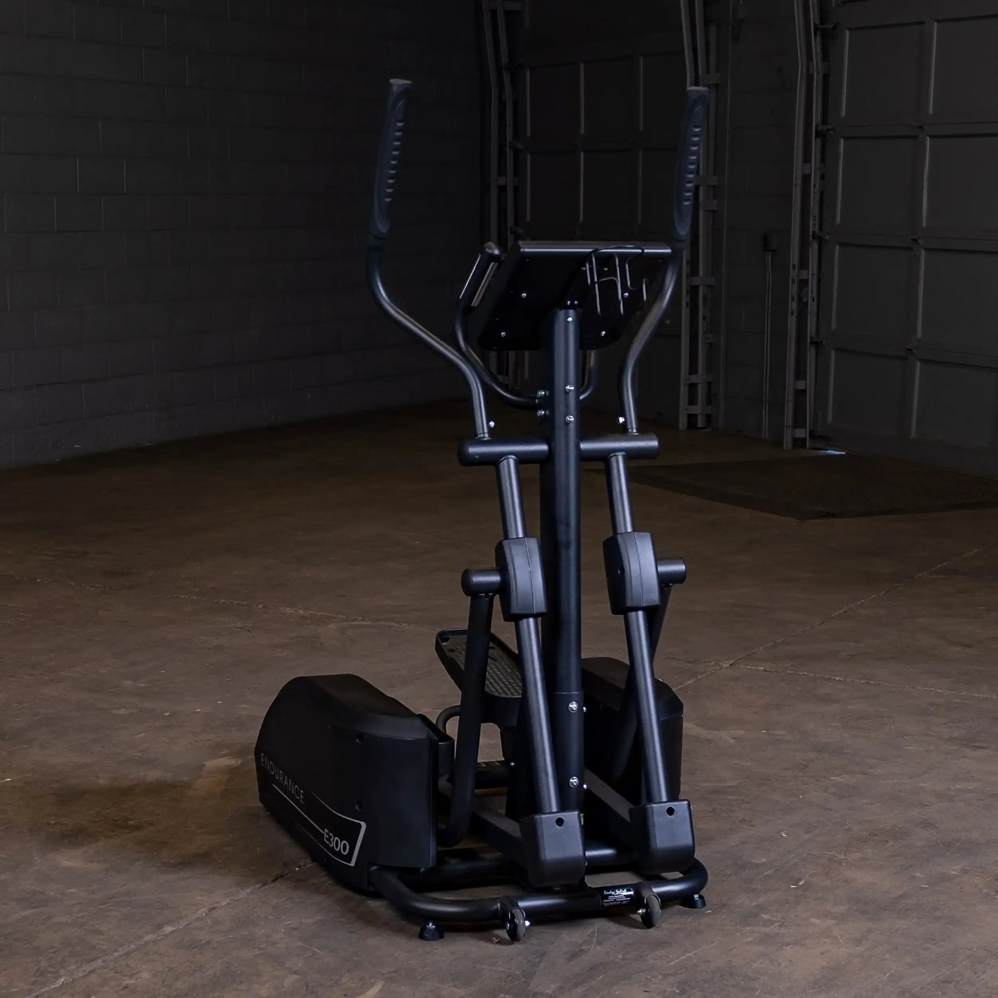 Endurance E300 elliptical trainer in a dimly lit garage.