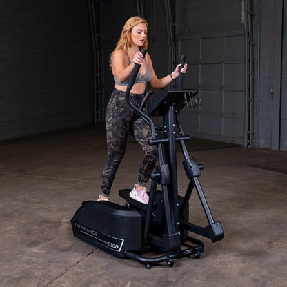 Woman using Endurance E300 elliptical trainer in a gym.