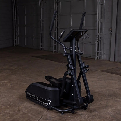 Endurance E400 elliptical trainer in a dimly lit gym with black frame and compact design.