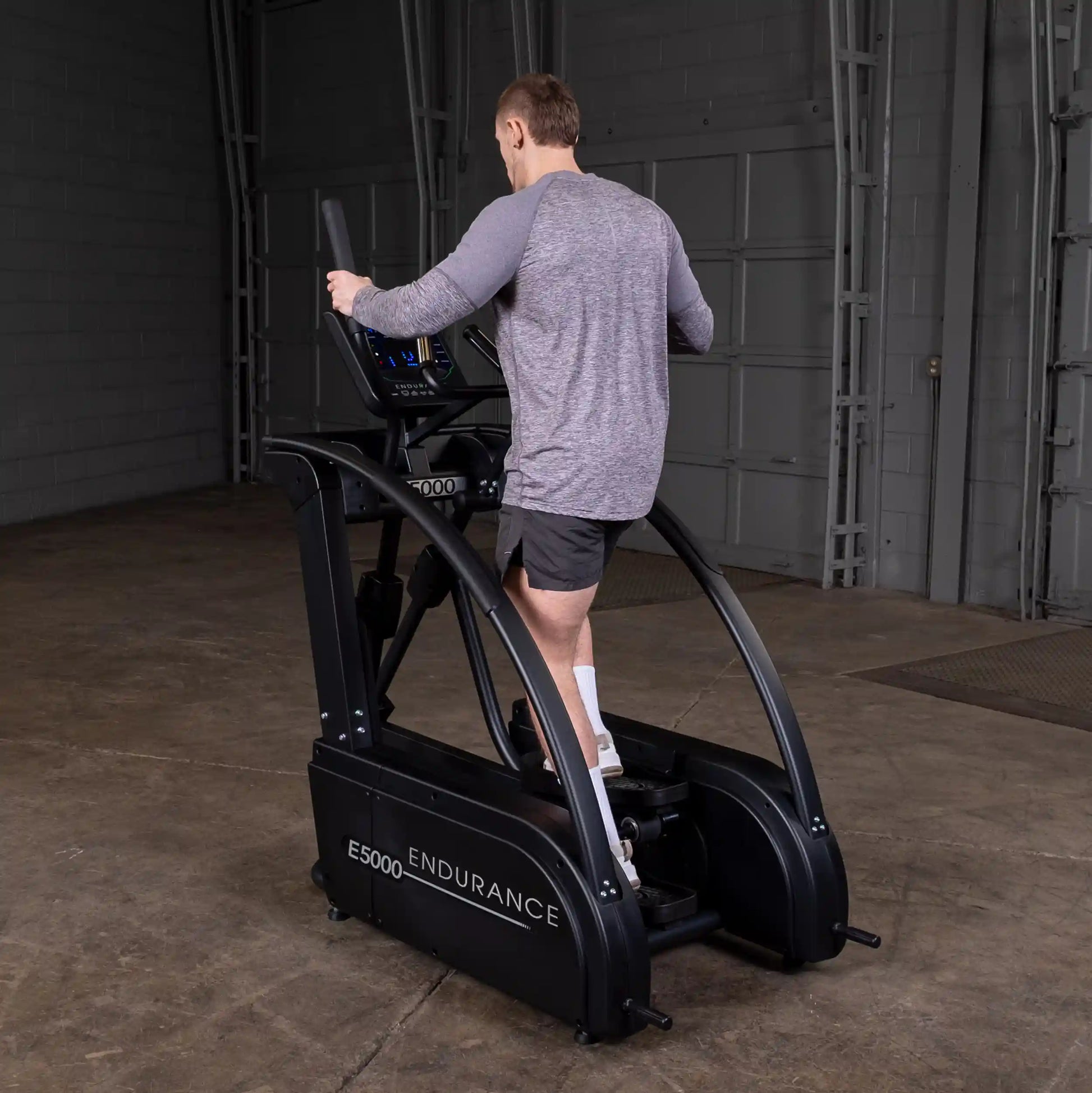 Man using Endurance E5000 elliptical trainer in a gym.