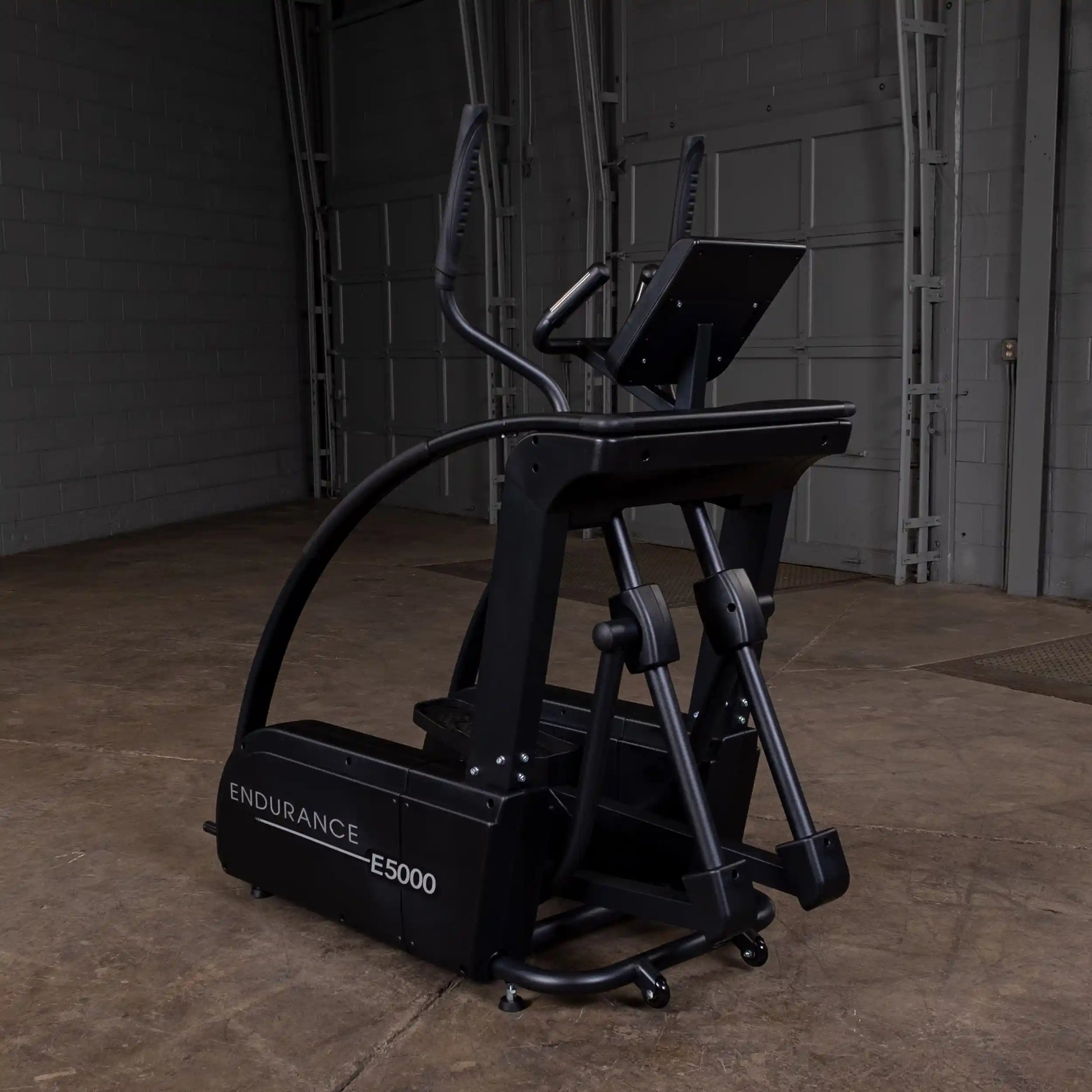 Endurance E5000 elliptical machine in black with a sleek design in a warehouse setting.