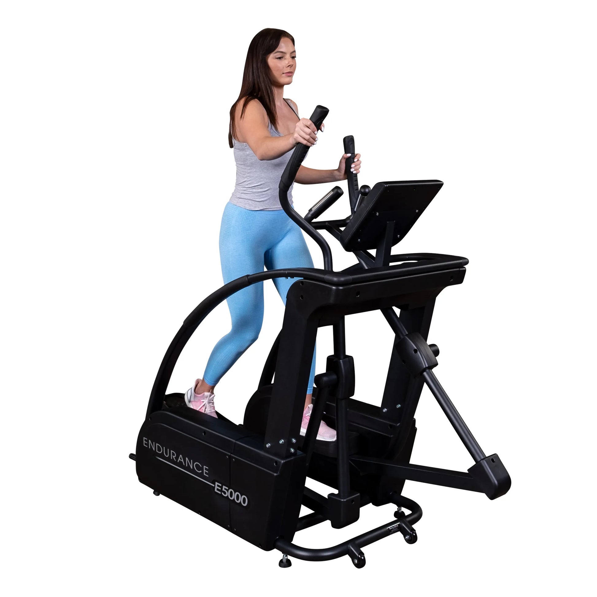 Woman using Endurance E5000 elliptical trainer in blue leggings.