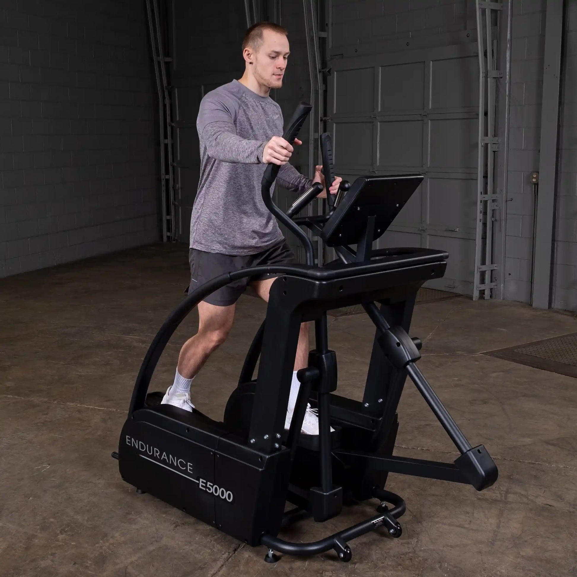 Man exercising on Endurance E5000 elliptical in a gym.