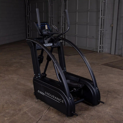 Endurance E5000 elliptical in dark finish, featuring dual curved handlebars in a spacious garage setting.