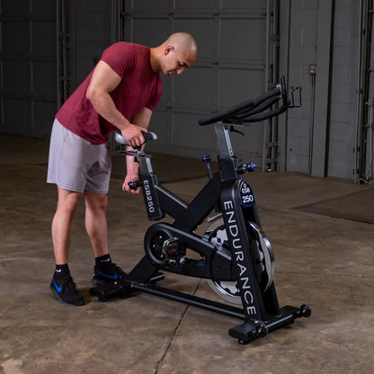 Man adjusting Endurance ESB250 exercise bike in a garage gym.