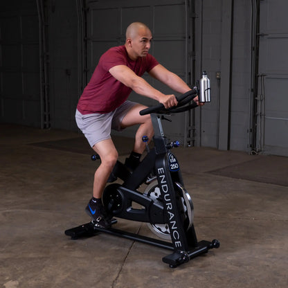 Man cycling on Endurance ESB 250 exercise bike in a garage.