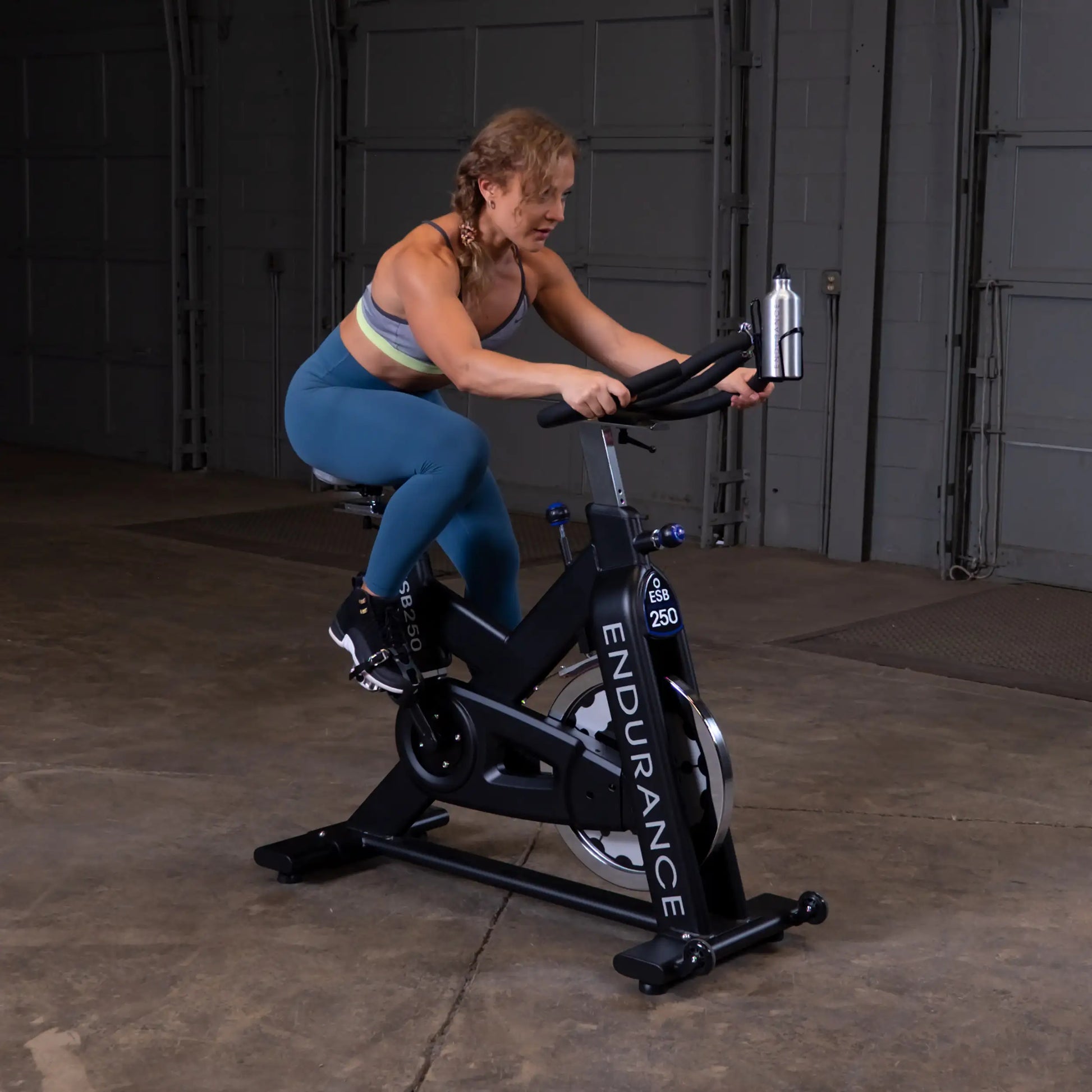 Woman cycling on Endurance ESB250 spin bike in a gym.