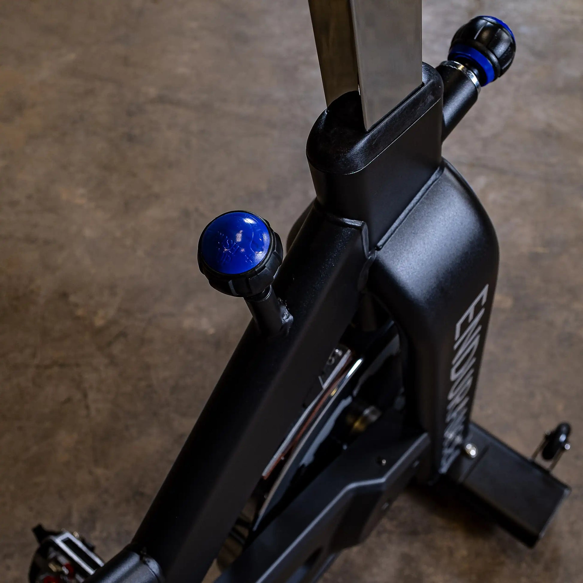Endurance stationary bike with blue adjustment knobs on a black frame.