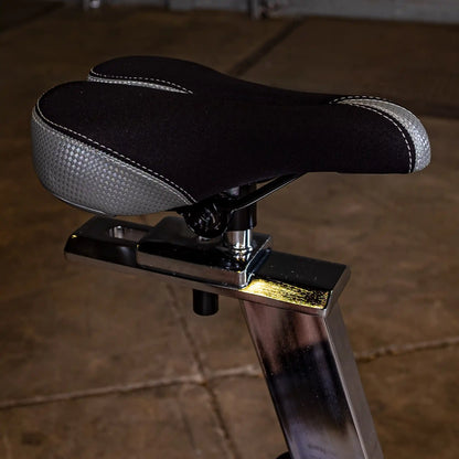 Black and gray bike seat with ergonomic design on a metallic post.