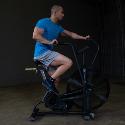 Man exercising on black Endurance air bike in gym.
