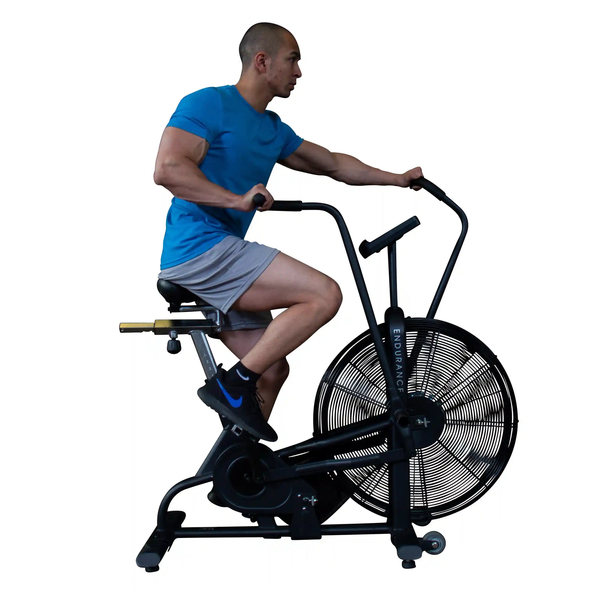 Man exercising on Endurance air bike, wearing blue shirt and gray shorts.