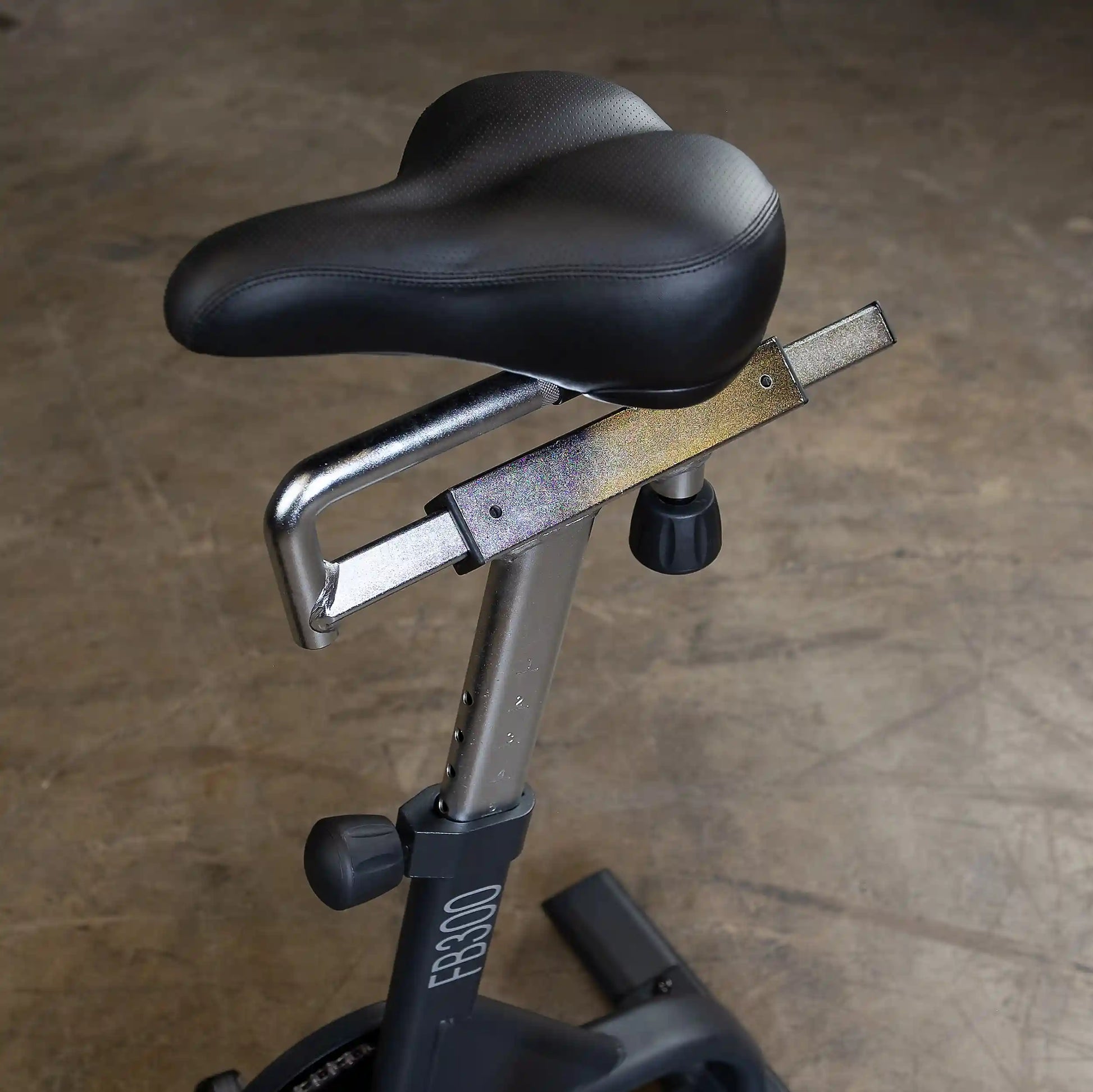 FB300 exercise bike seat with black cushion and adjustable height feature.
