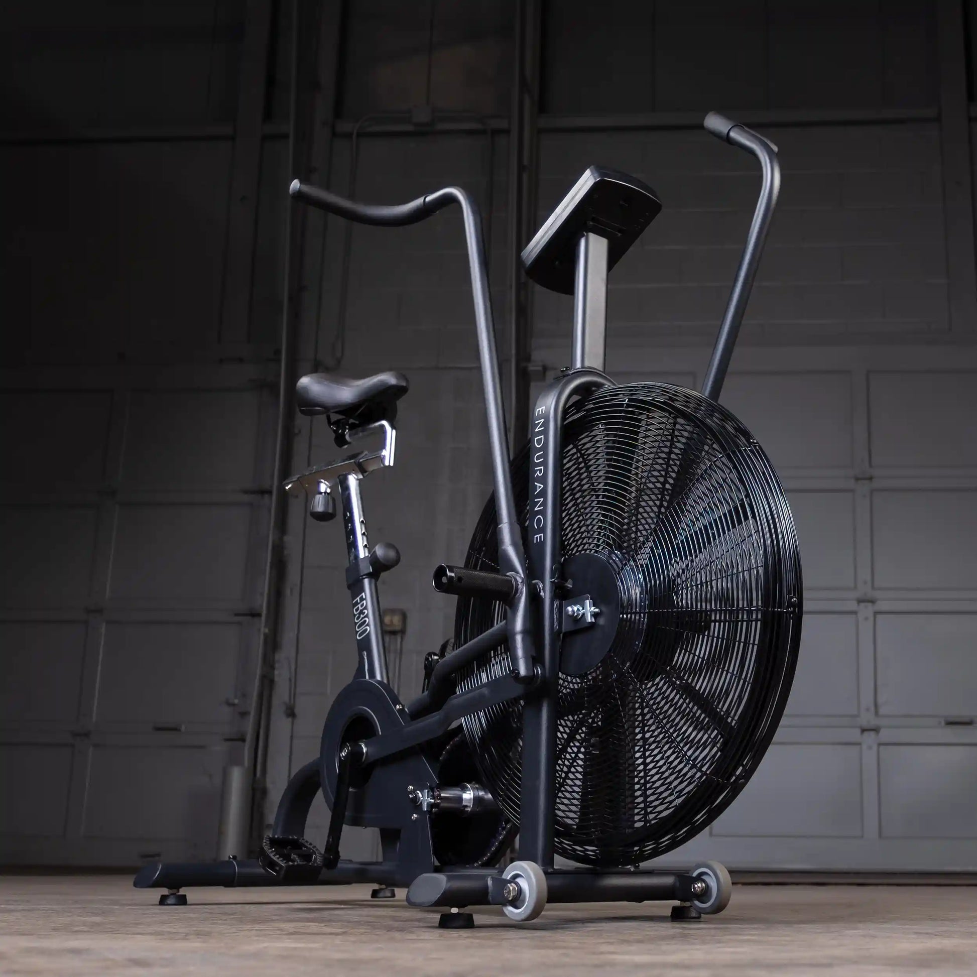 Black Endurance FB300 air bike with large front fan in a garage setting.