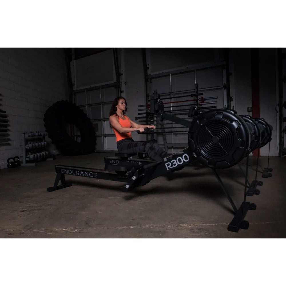 Woman using Endurance R300 rowing machine in a gym.