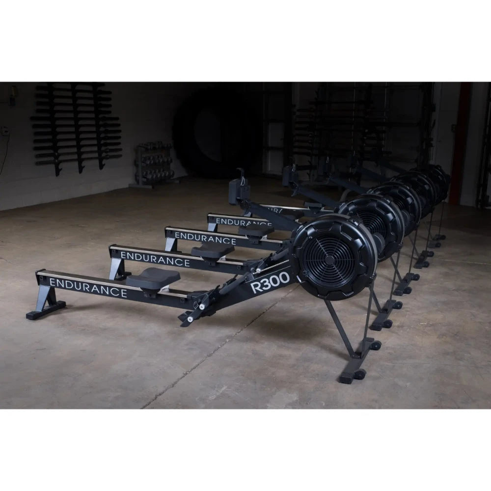 Endurance R300 rowing machines in a gym, black color, lined up for fitness training.