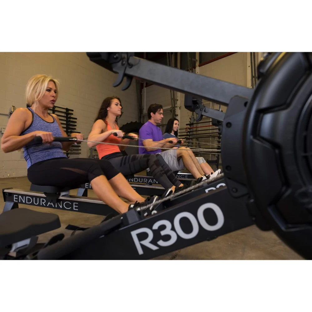 Group workout on Endurance R300 rowing machines in gym.