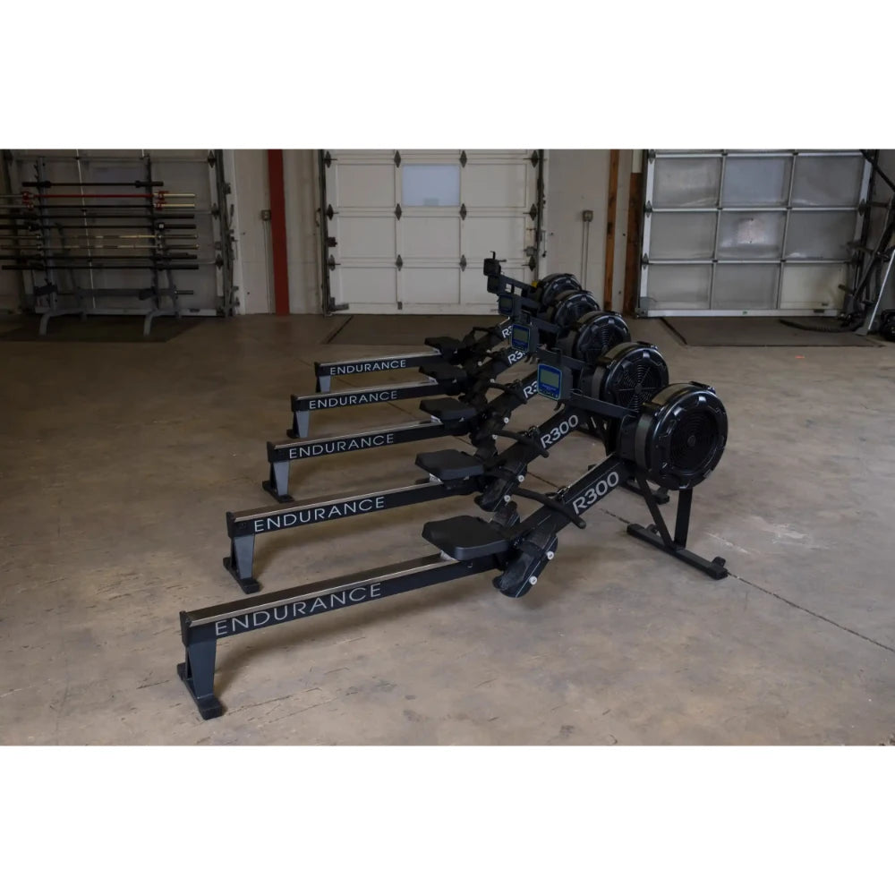 Endurance R300 rowing machines lined up in a gym with concrete flooring.