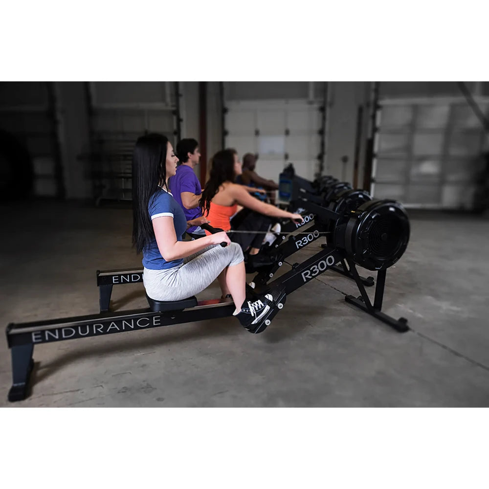 People exercising on Endurance R300 rowing machines in a gym.