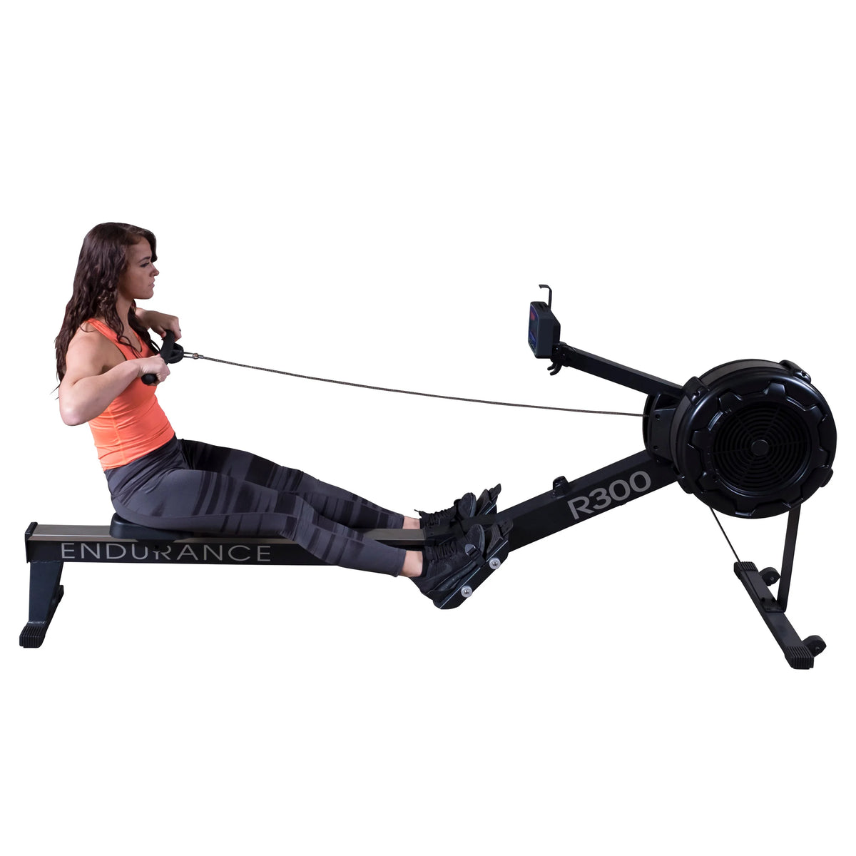 Woman using Endurance R300 rowing machine with black frame for fitness workout.