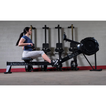 Woman using Endurance R300 rowing machine in gym.