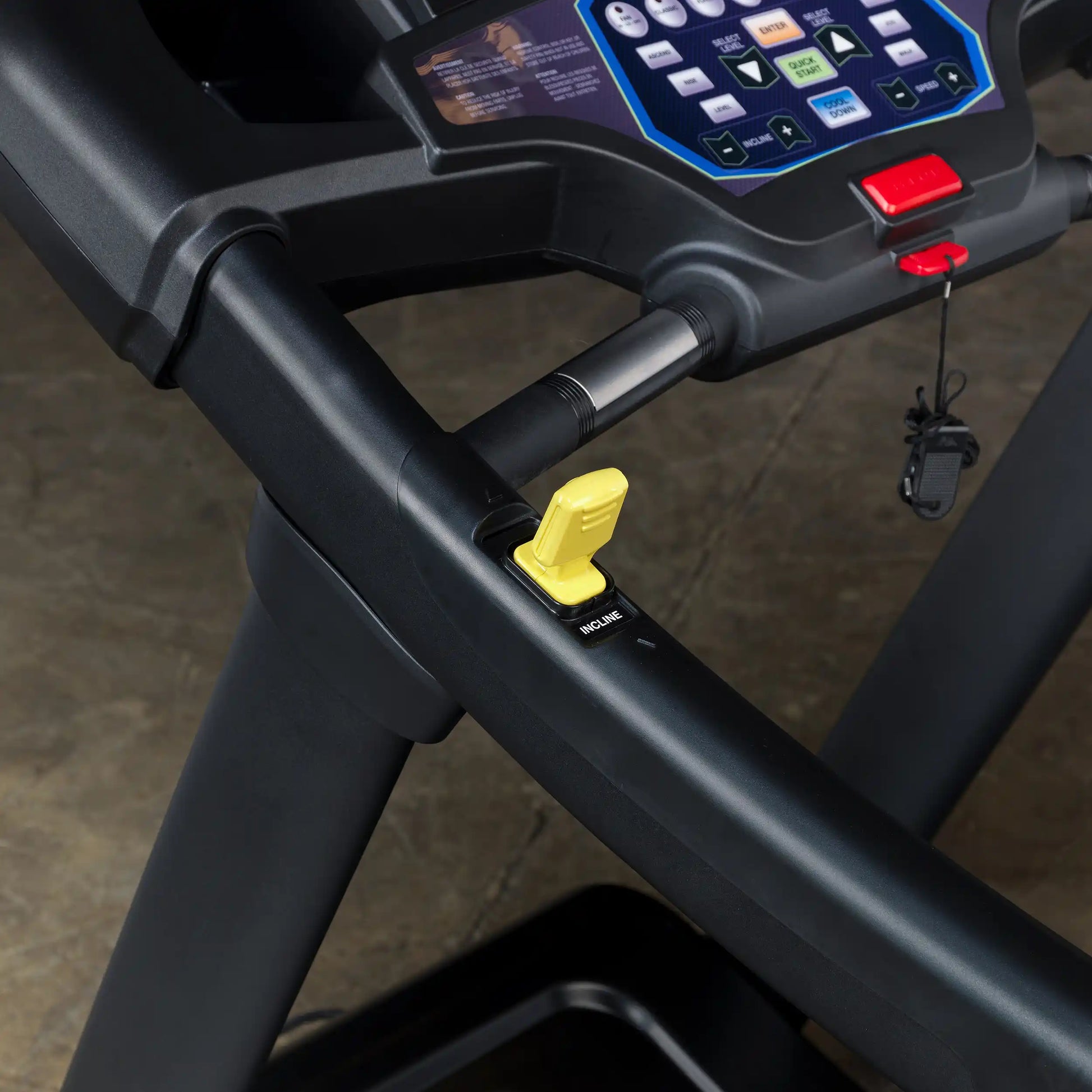 Treadmill control panel with yellow incline lever and safety key.