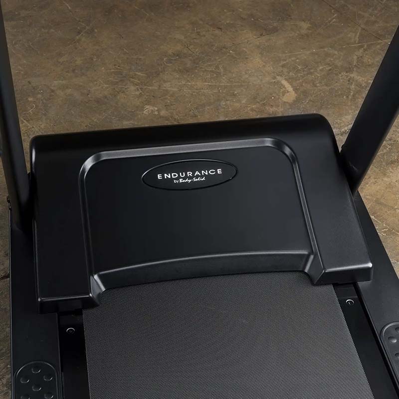 Endurance treadmill by Body-Solid on a textured floor, featuring a sleek black design.