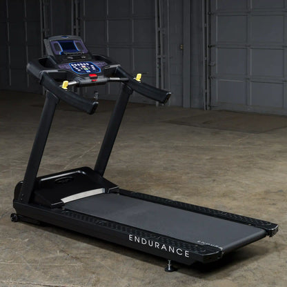 Endurance treadmill with digital display and black finish in a garage setting.