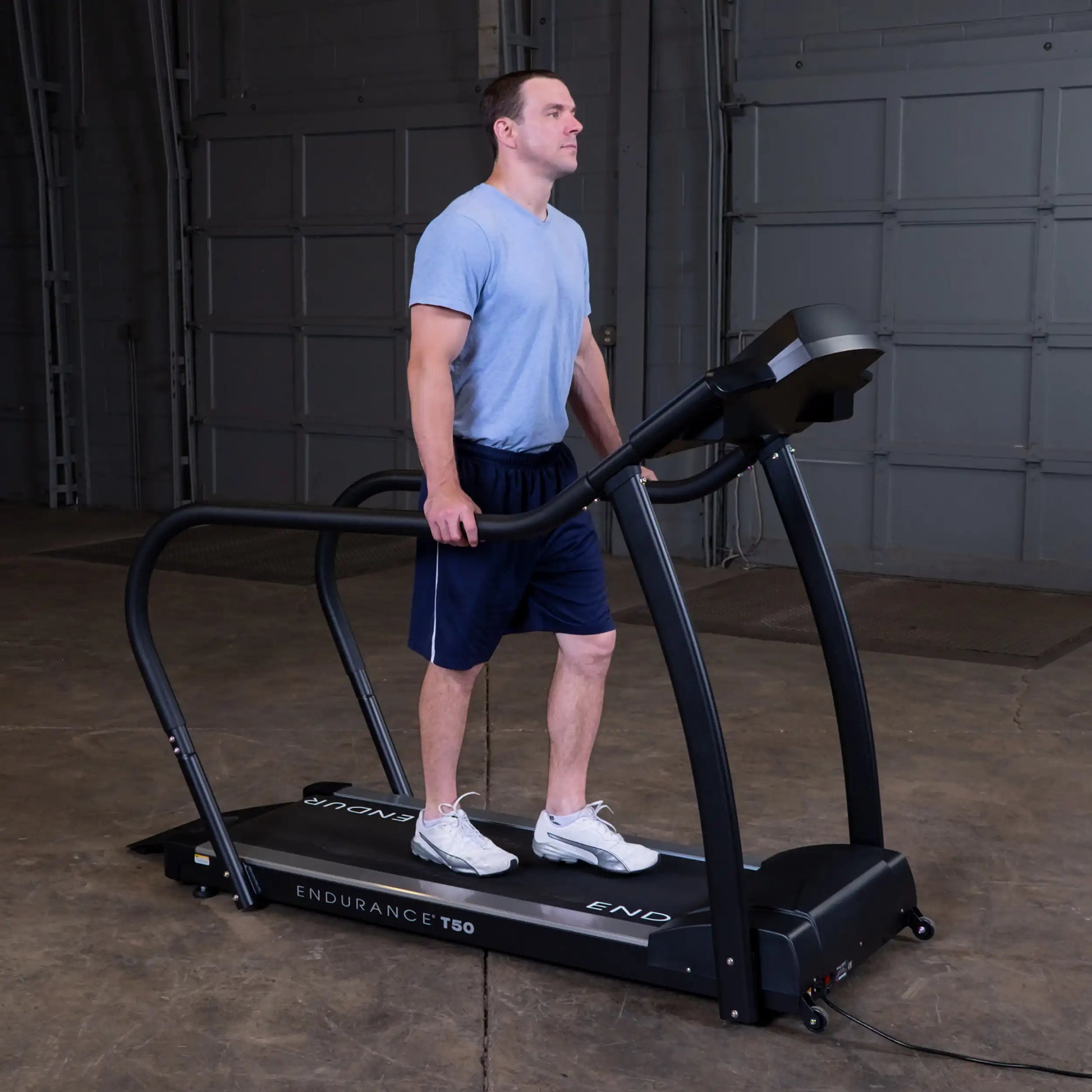 Man using Endurance T50 treadmill in a garage setting.