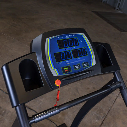 Endurance treadmill console with digital display and red safety key in a gym setting.