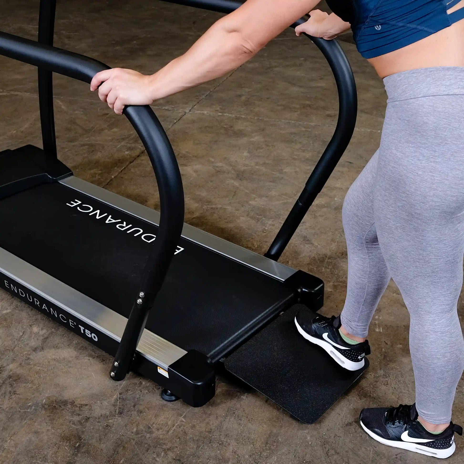 Person using Endurance T50 treadmill with curved handlebars.