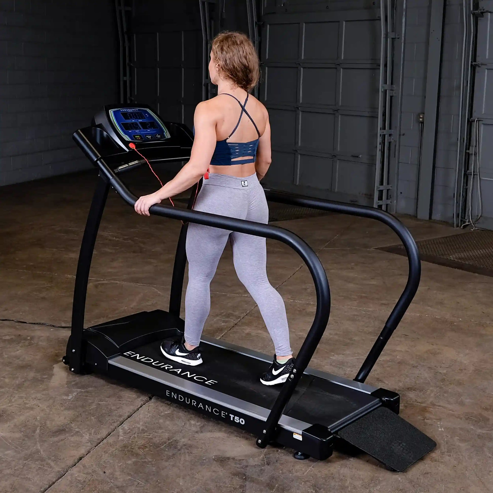 Woman exercising on Endurance T50 treadmill in gray leggings.
