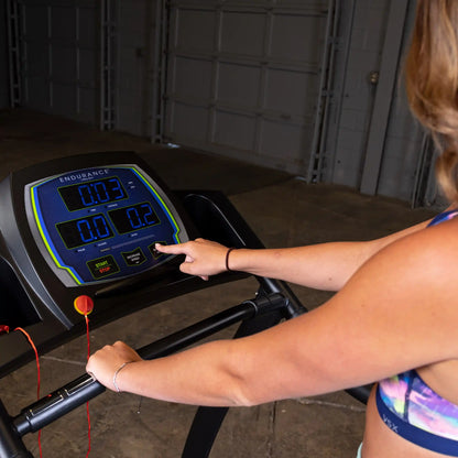 Person using Endurance treadmill control panel in a gym setting.