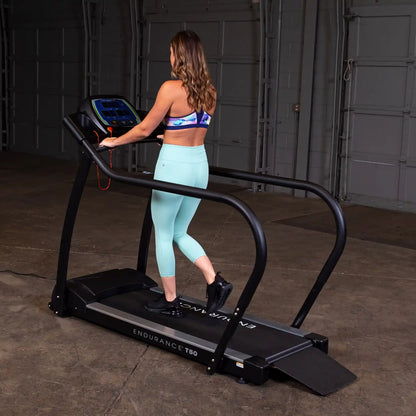 Woman exercising on Endurance T50 treadmill in teal leggings.