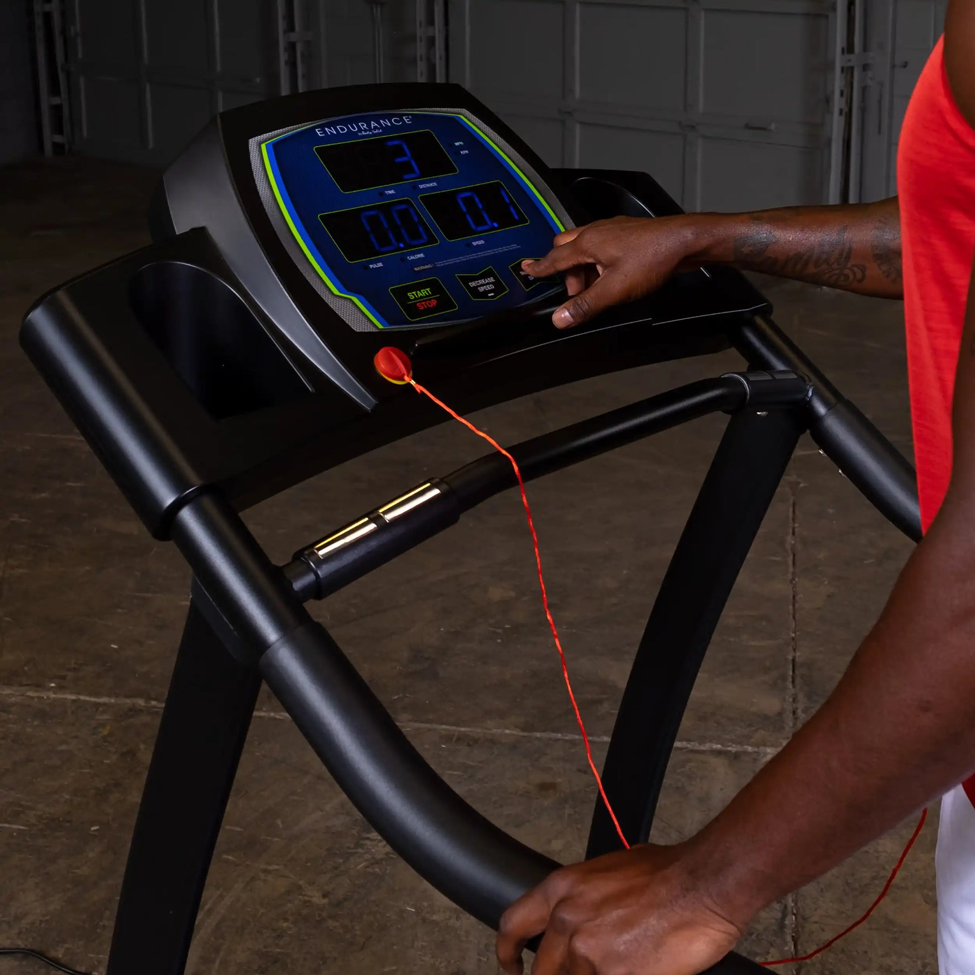 Endurance treadmill console with digital display in use by person in red tank top.