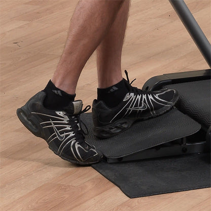 Man using Nike black sneakers on treadmill incline.