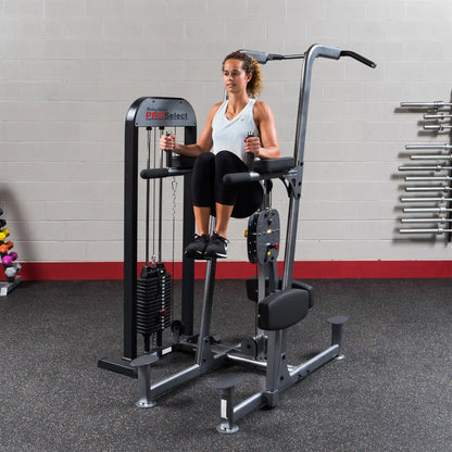 Woman using Body-Solid Pro Select knee raise machine in gym.