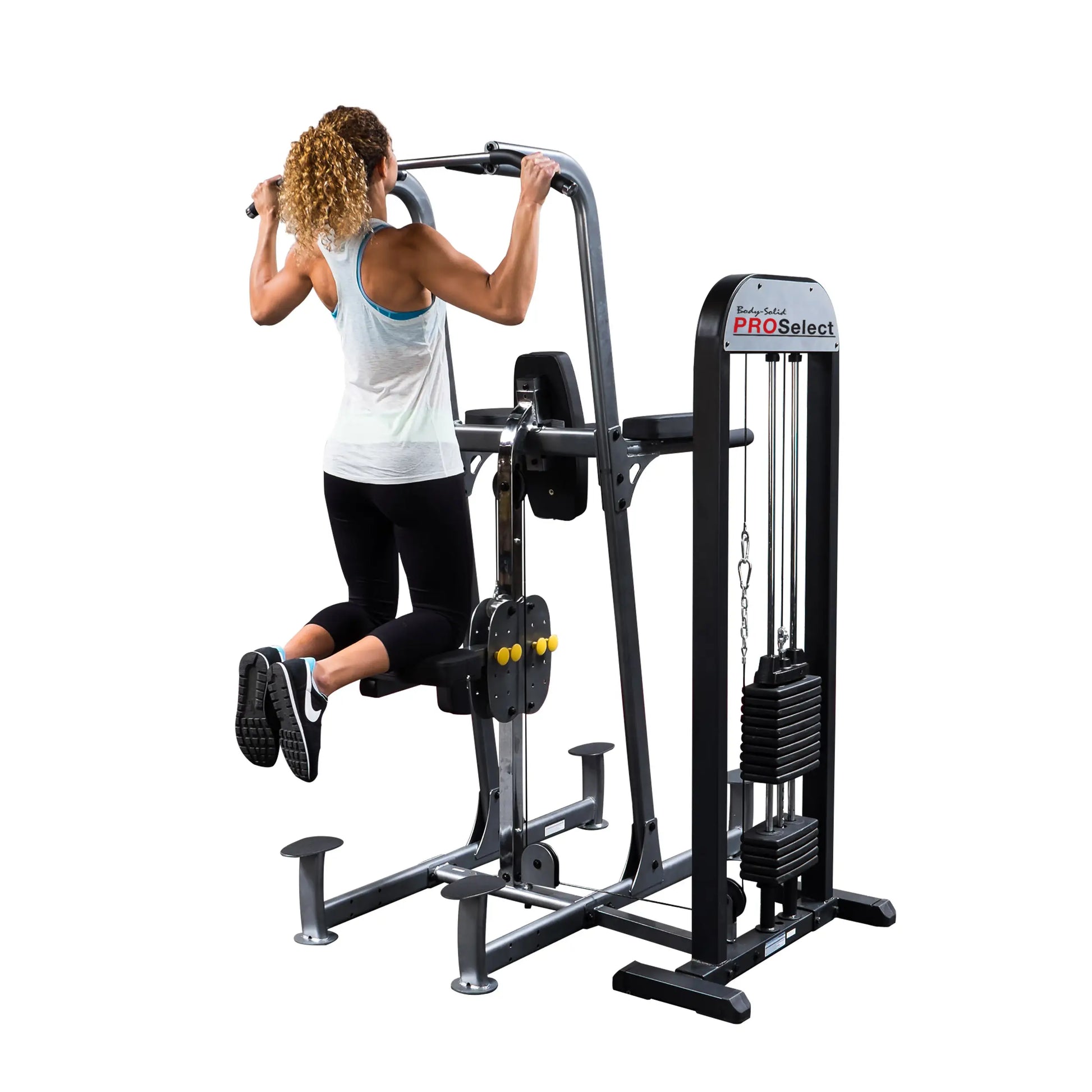 Woman using Body-Solid PRO Select pull-up machine with padded knee support.