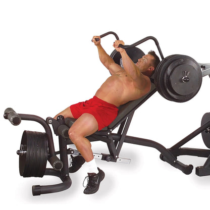 Man using a seated leg press machine, wearing red shorts, for strength training.