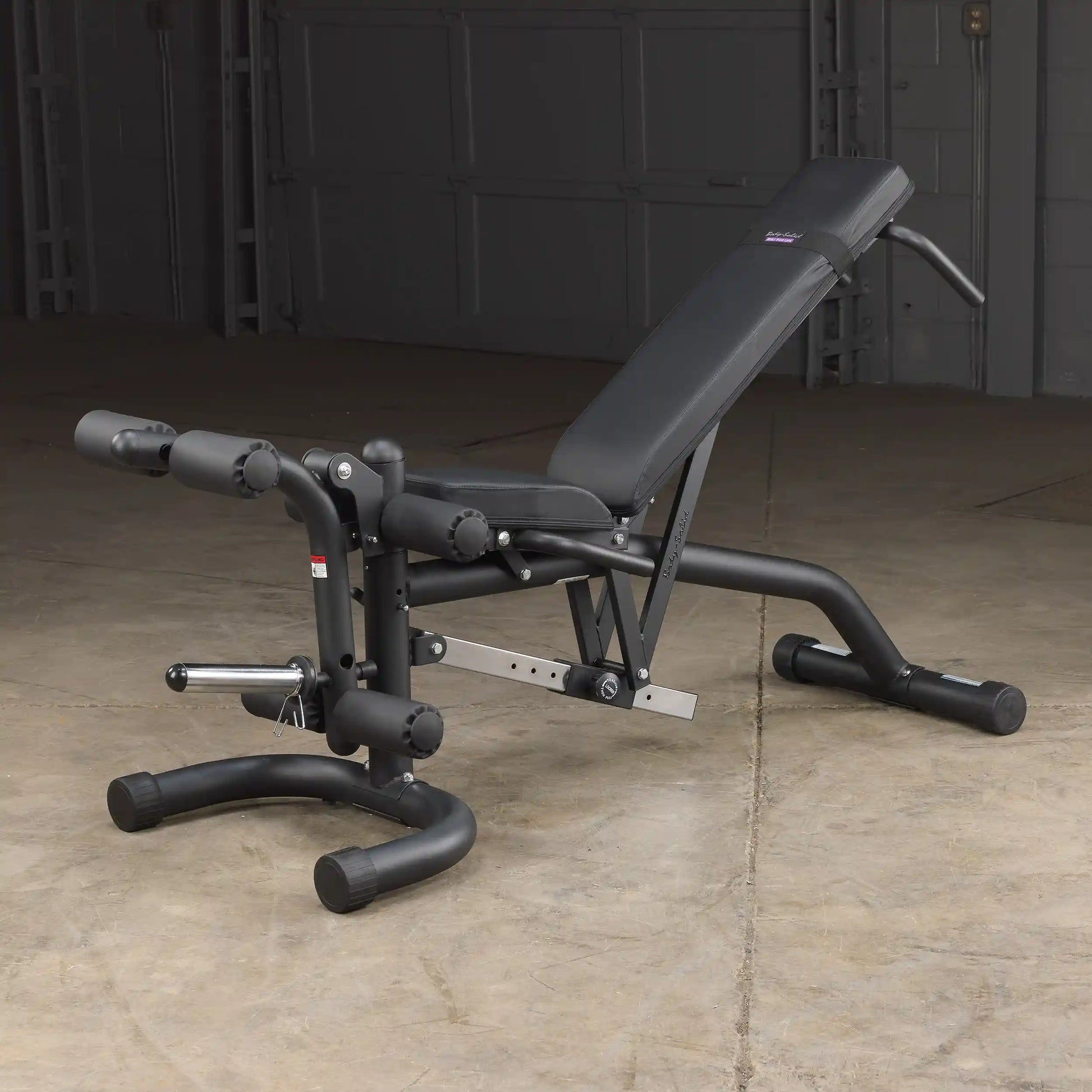 Adjustable weight bench with black padding in a garage gym setup.
