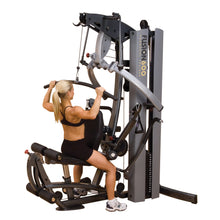 Woman using Body-Solid Fusion 600 gym machine for strength training.