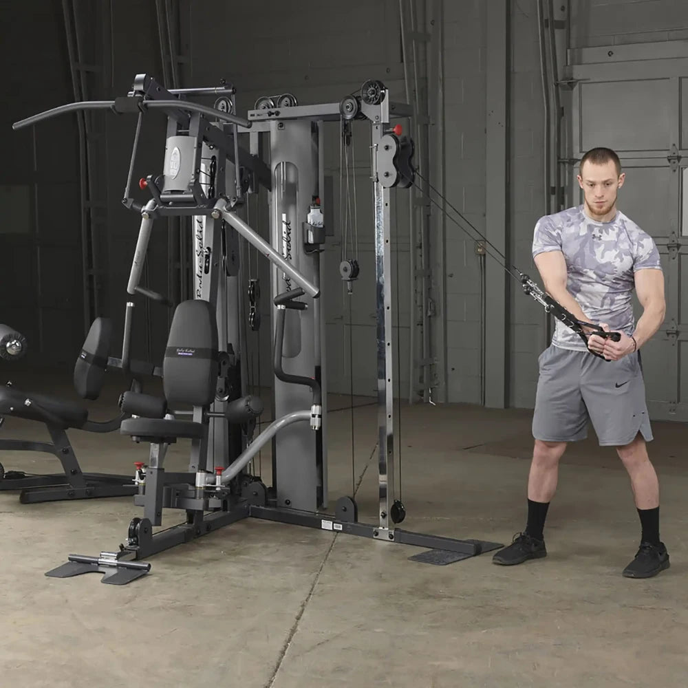Man using Body-Solid home gym with cable crossover in a gray workout outfit.