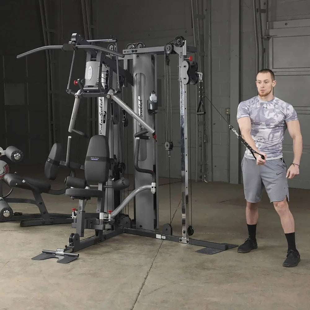 Man using Body-Solid home gym with cable machine in gray workout attire.